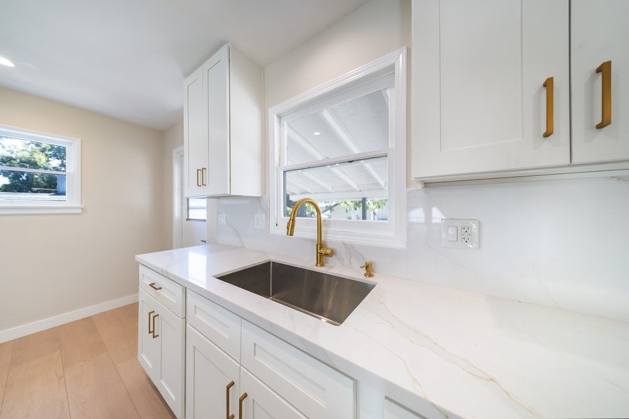Kitchen detail with gold faucet and white countertops - quality finishes by Nazerian Builders